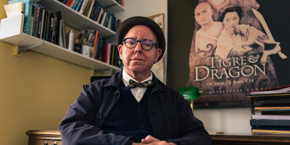James Schamus sits in his office in front of a poster for 'Tigre & Dragon'
