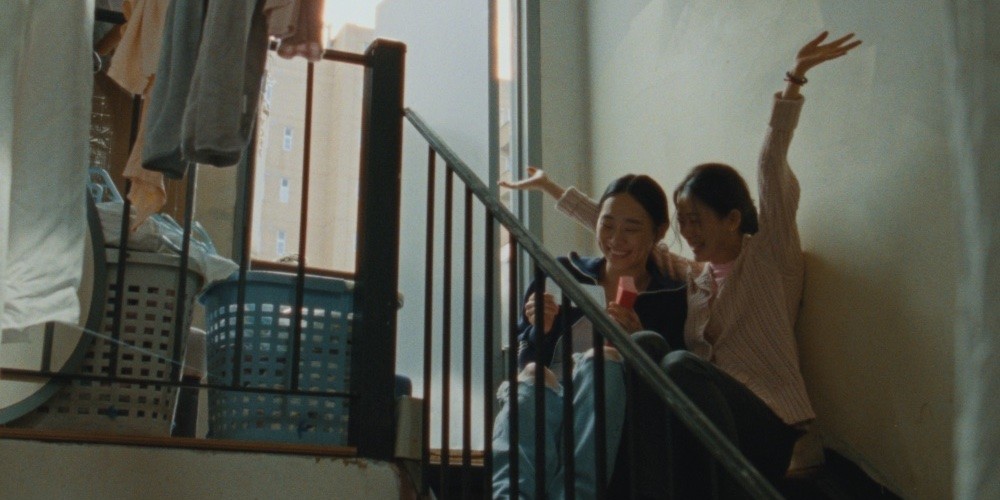 still from "blue sun palace," two women on a staircase