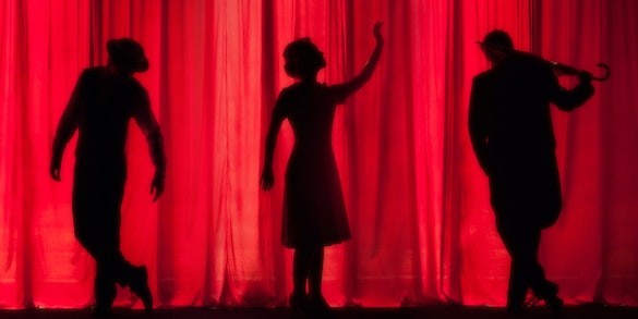 Black shadows in front of red curtain