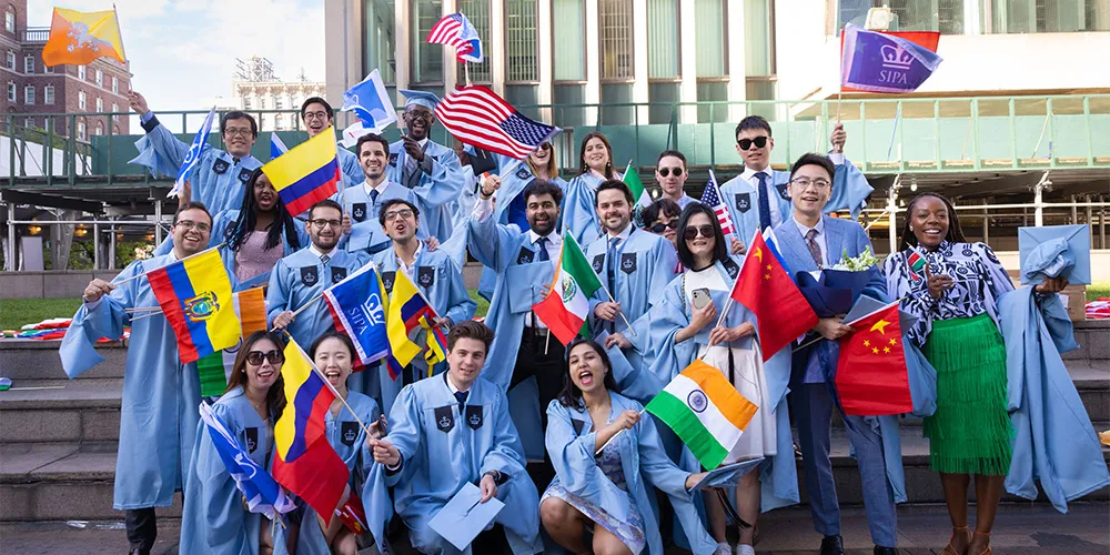 Graduates holding international flags