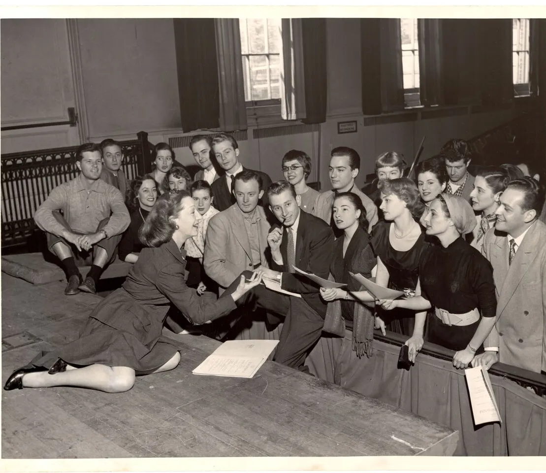 woman on stage performing to group of students