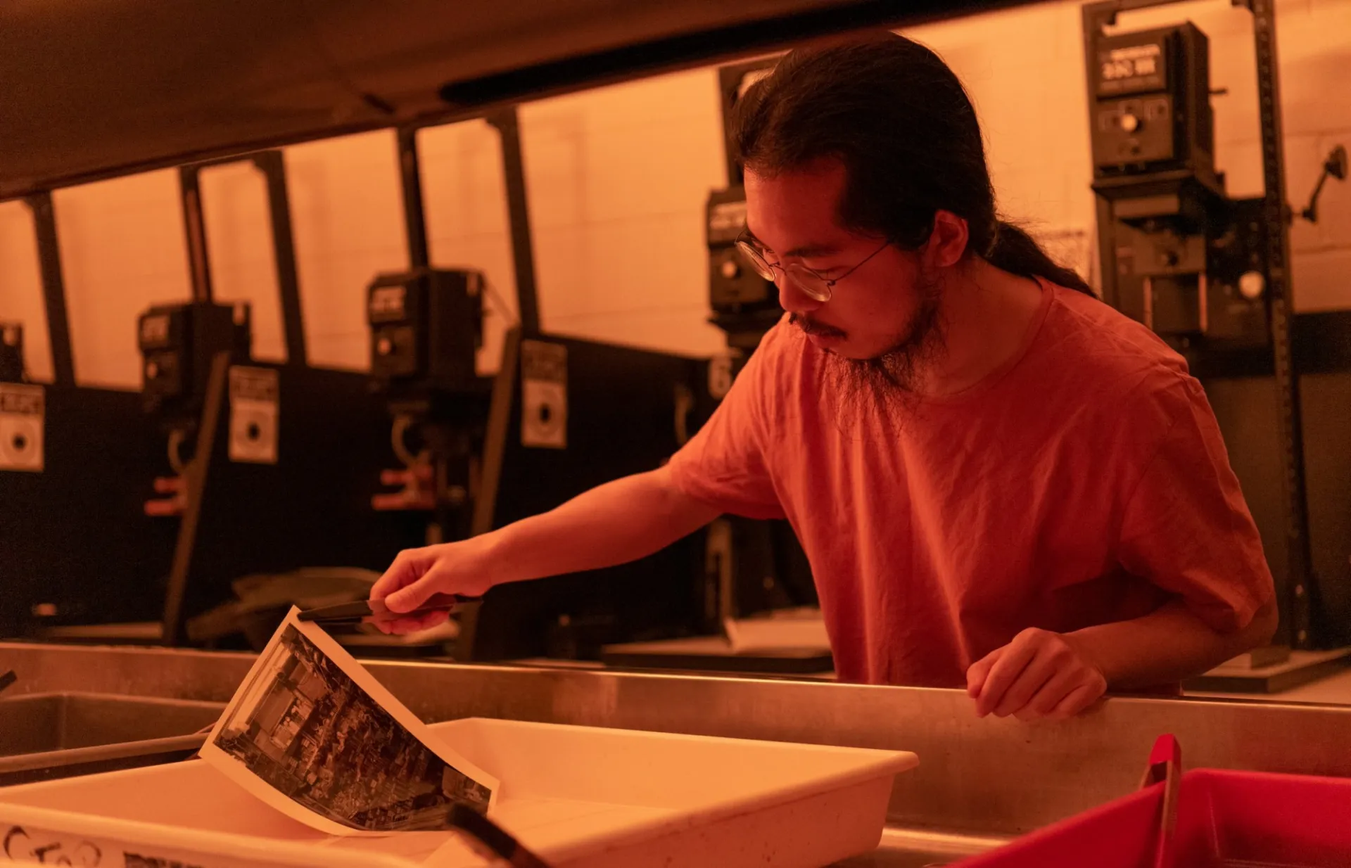 A student develops film photography in the School of the Arts darkroom