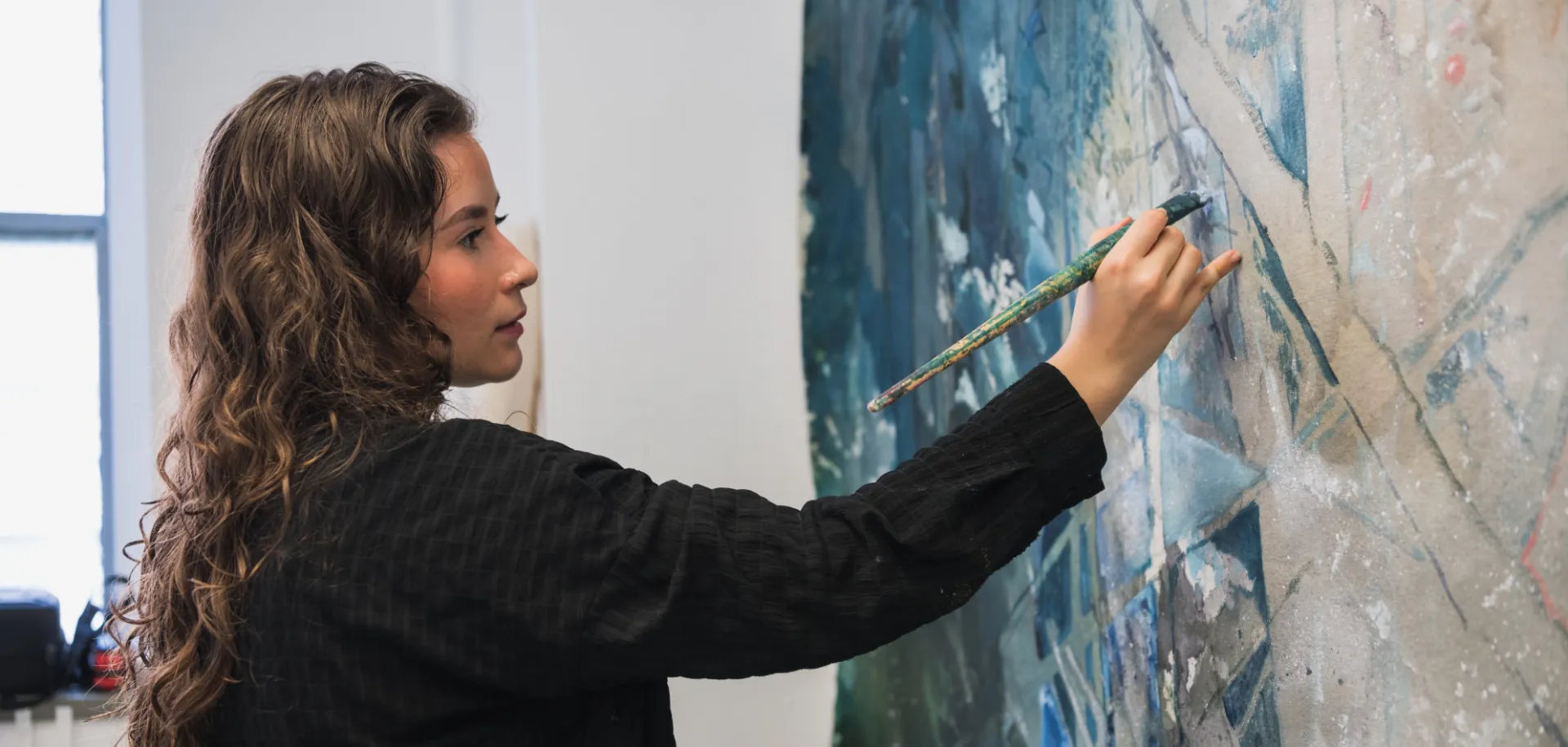 an artist paints on a canvas