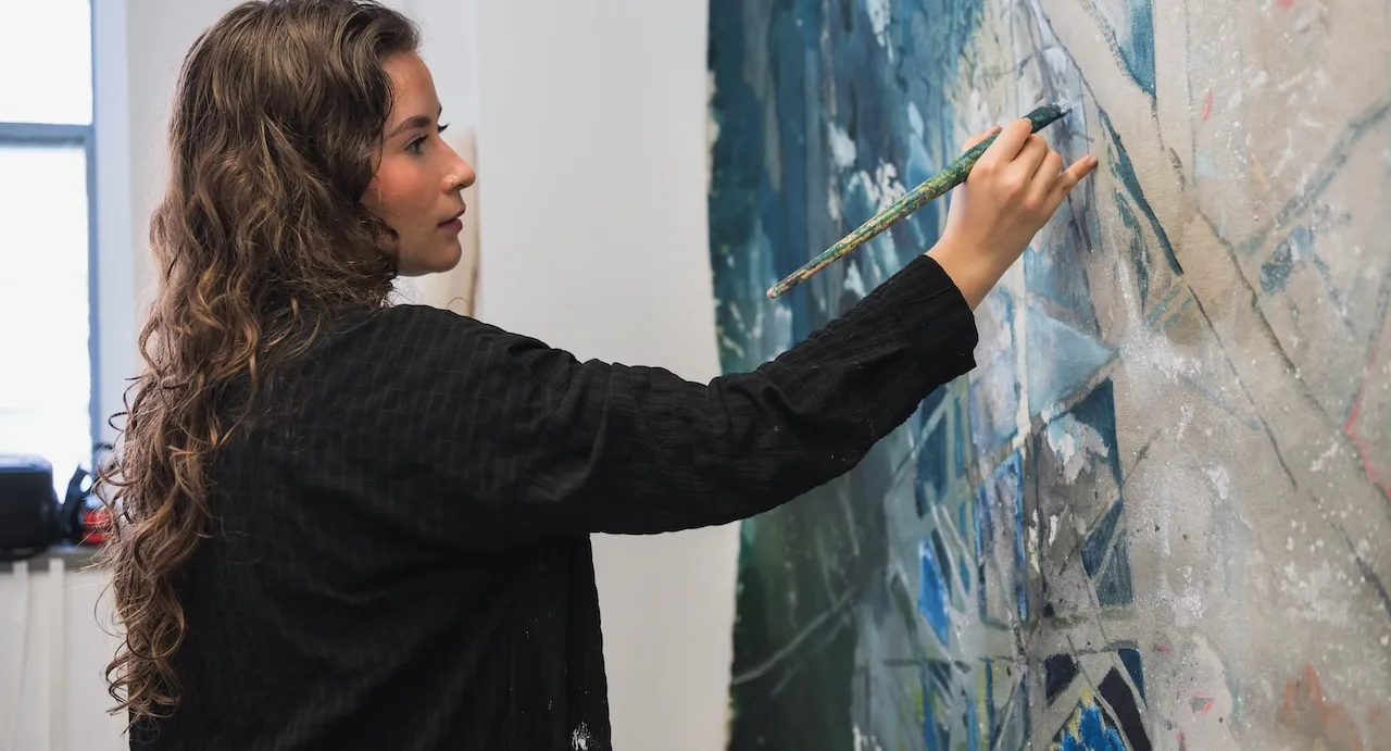 an artist paints a canvas in a studio