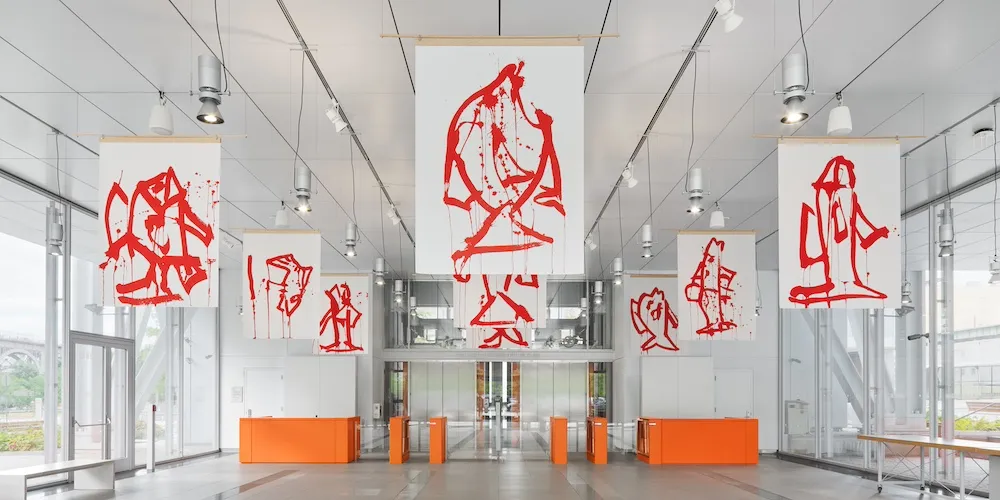 banners displaying red ink drawings of fish installed in a building lobby
