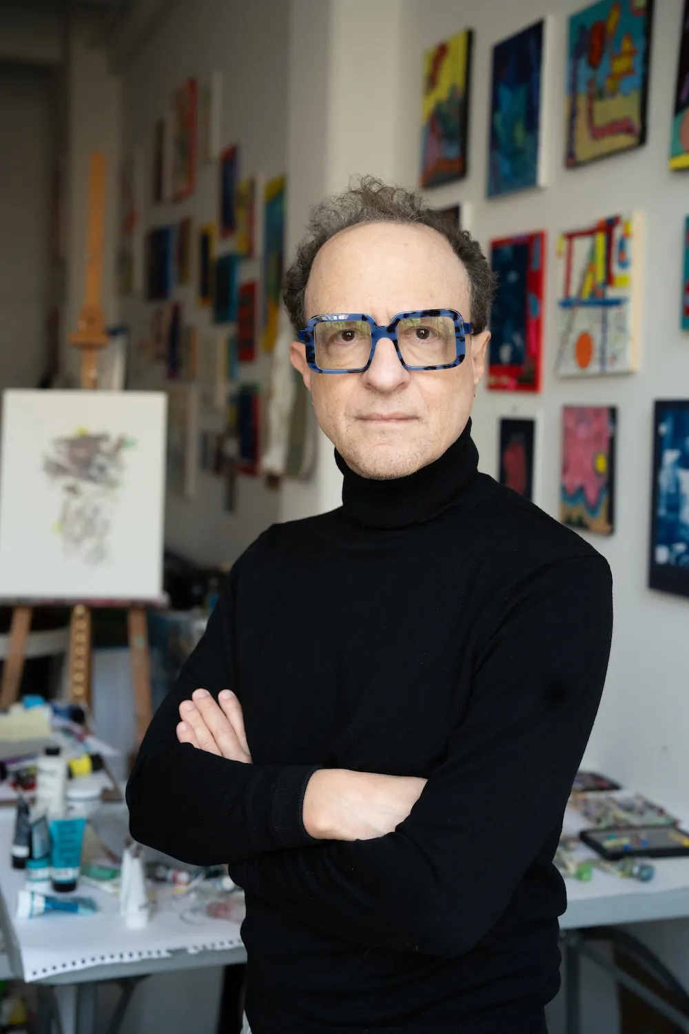 white man wearing a black turtle neck sweater and glasses