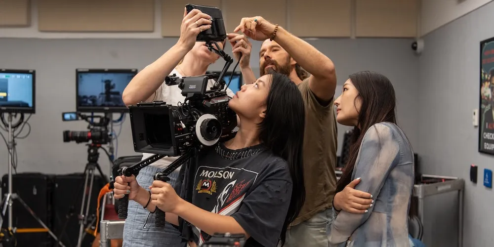 a group of students learn how to operate a hand-held camera