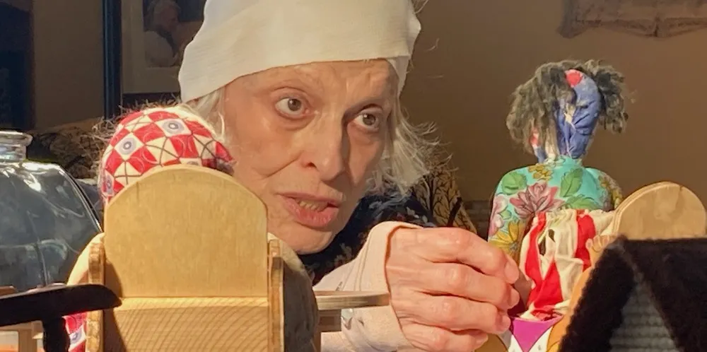 Close up of an elderly woman playing with a rag doll. 