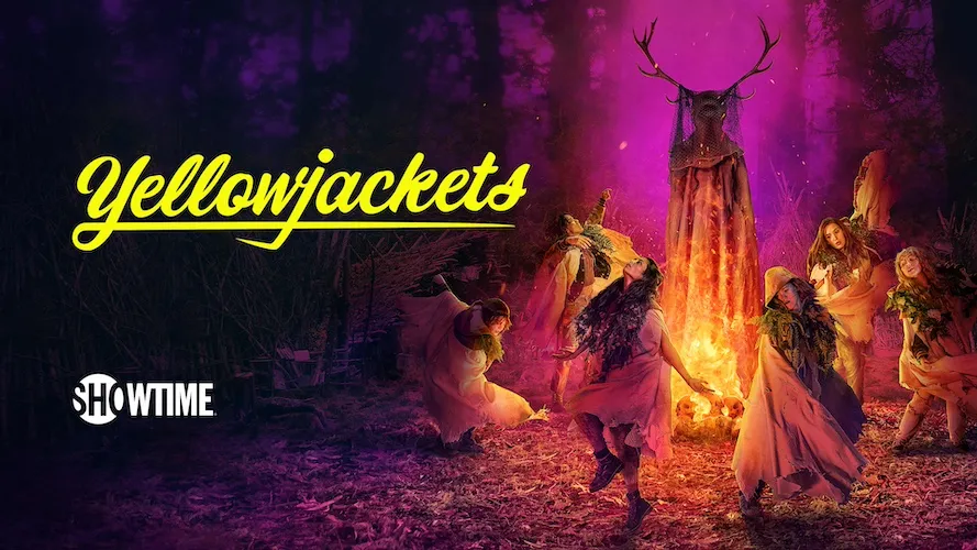 a group of girls dance around a bonfire near a cloaked figure