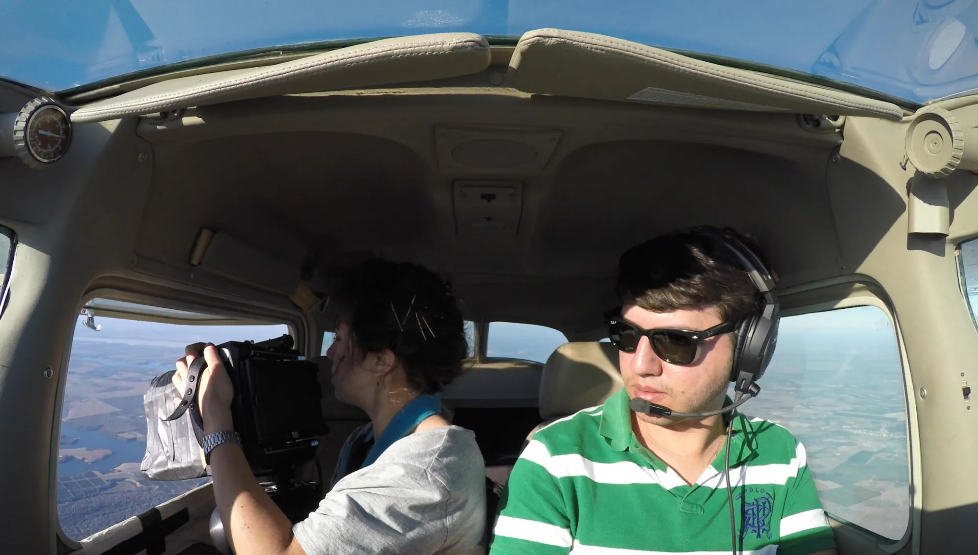 Two people film in from an airplane. 