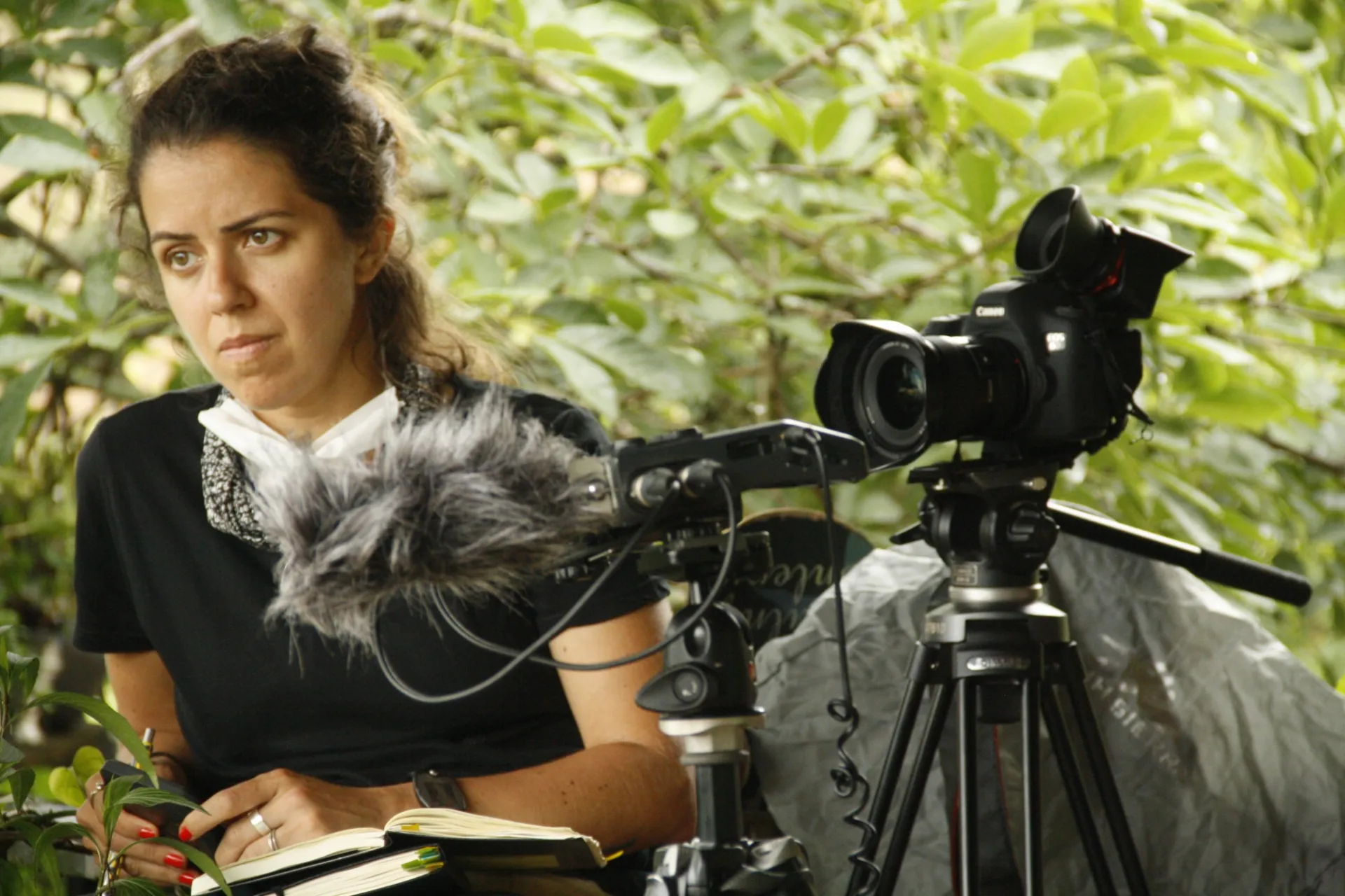 Woman with camera among foliage. 