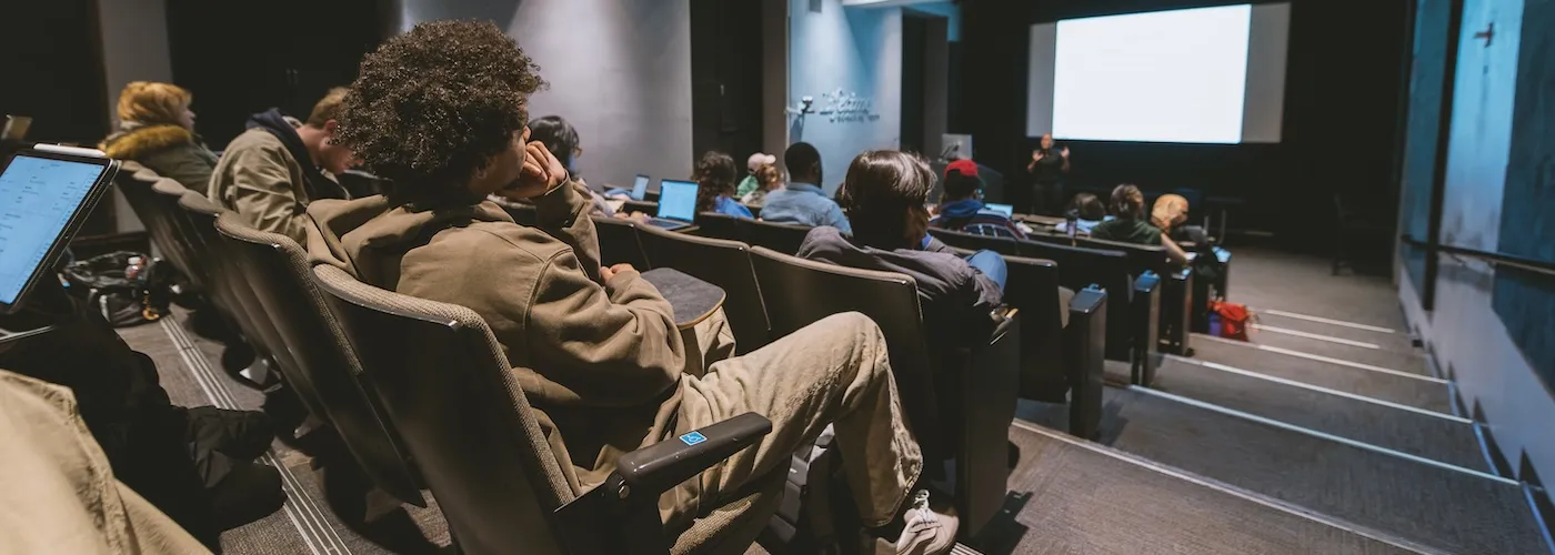 Students attend a lecture class taught by a professor.