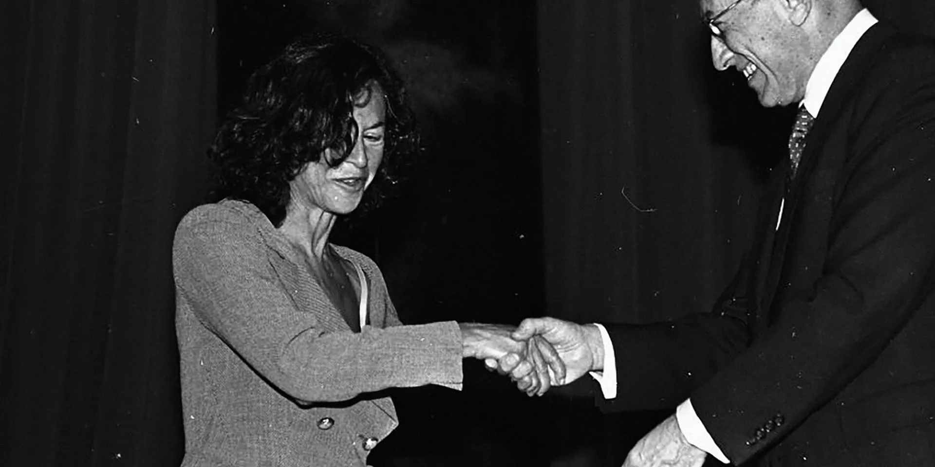 A woman shaking hands with a man