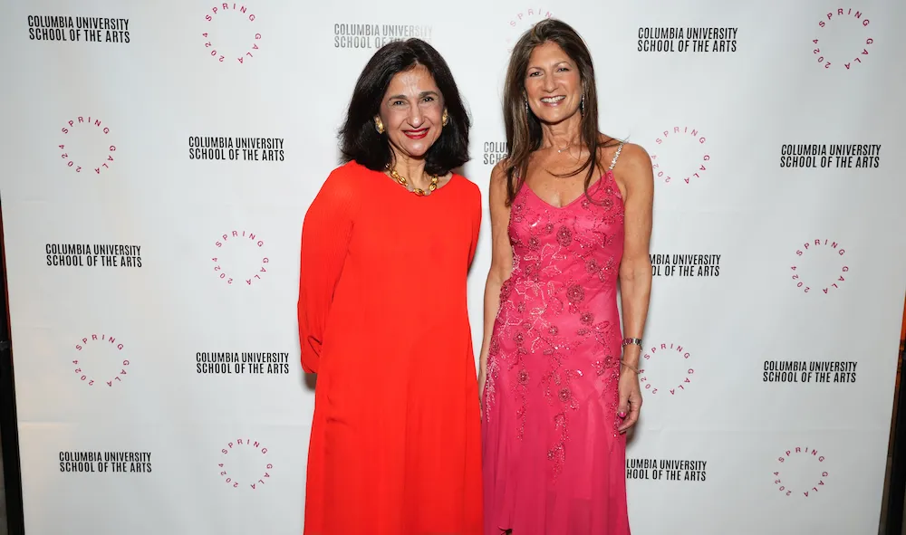 Two women in front of a step & repeat