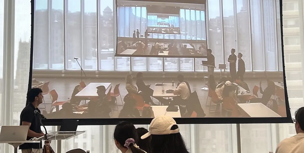 image of people working at tables projected onto a screen, repeating