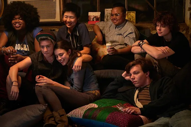 Group of people sit in a living room.