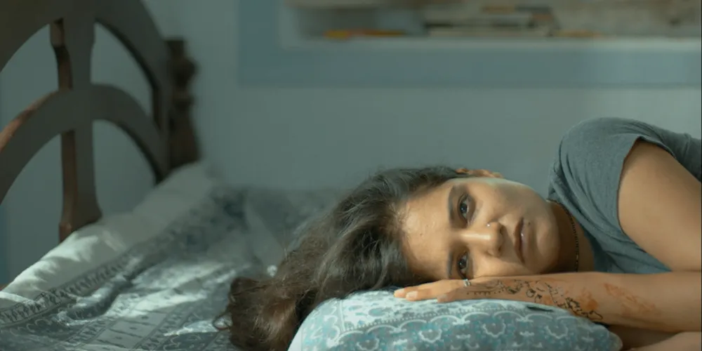 Woman laying horizontally in bed