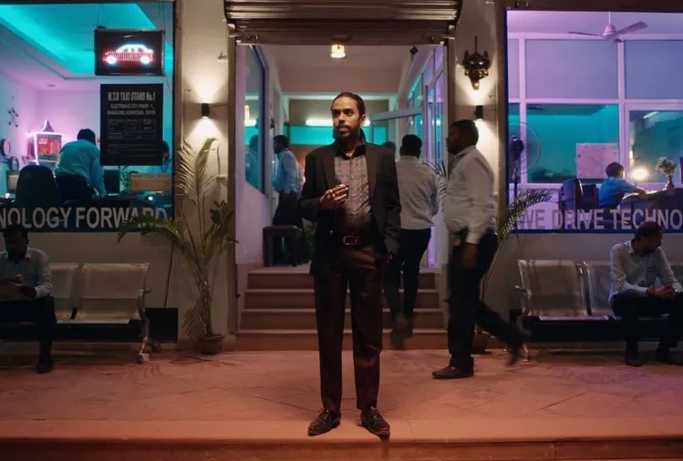 Man standing outside a neon lit store front