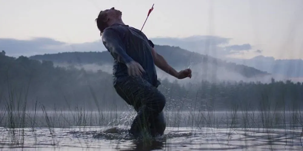 Man in marsh with arrow in his chest