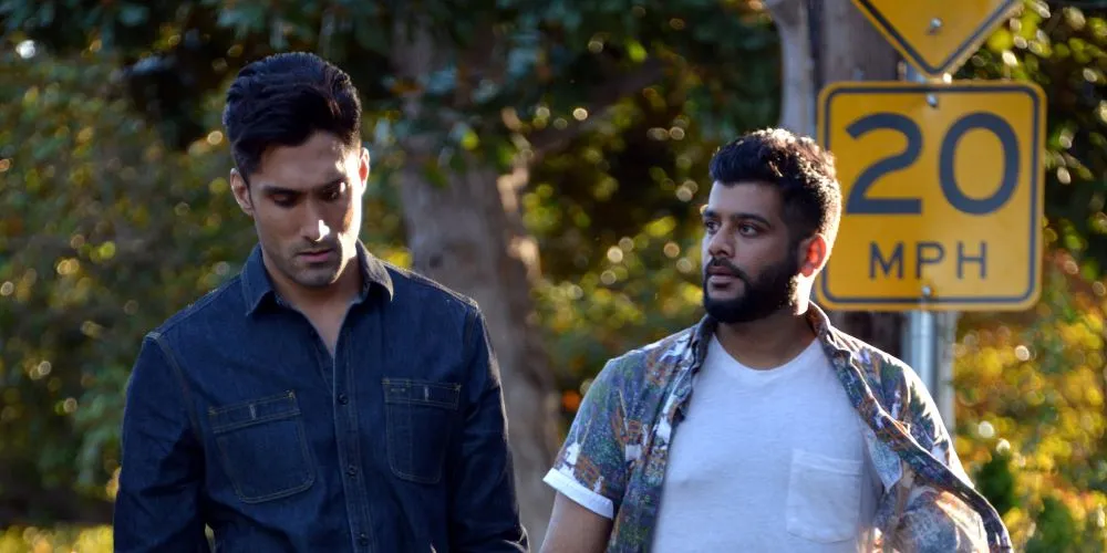 Still from 'Chee and T,' two man walk in a park.
