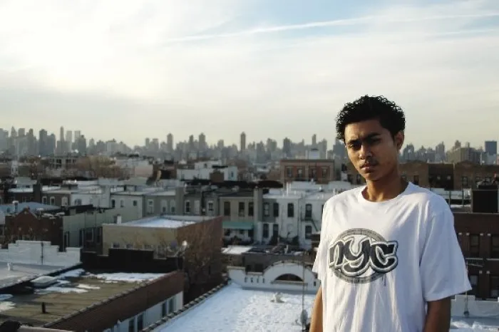 Still from "Punching at the Sun", a man stands on a rooftop overlooking a city.