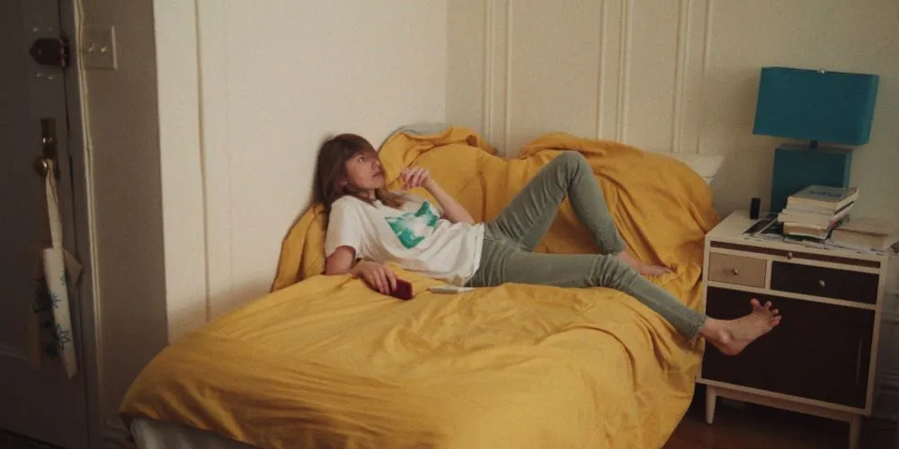 Teenager seated on bed