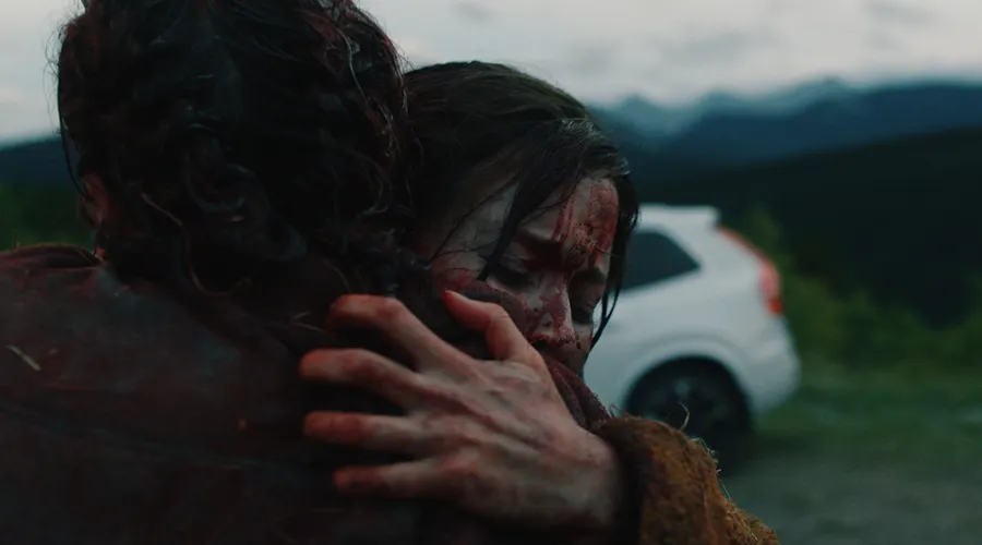 Two bloodied people hugging