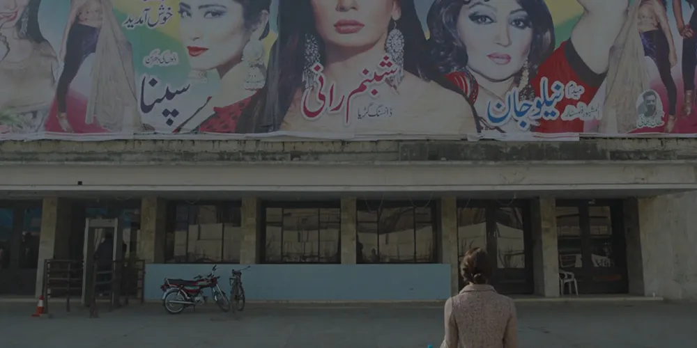 Woman gazing up and poster painted on building