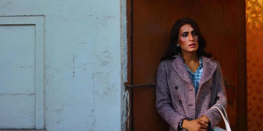Trans woman leaning against wall