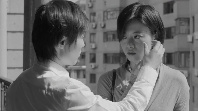 Two characters facing each other, one holds their hand to the other's cheek