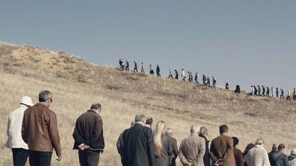 A long line of people across an arid landscape