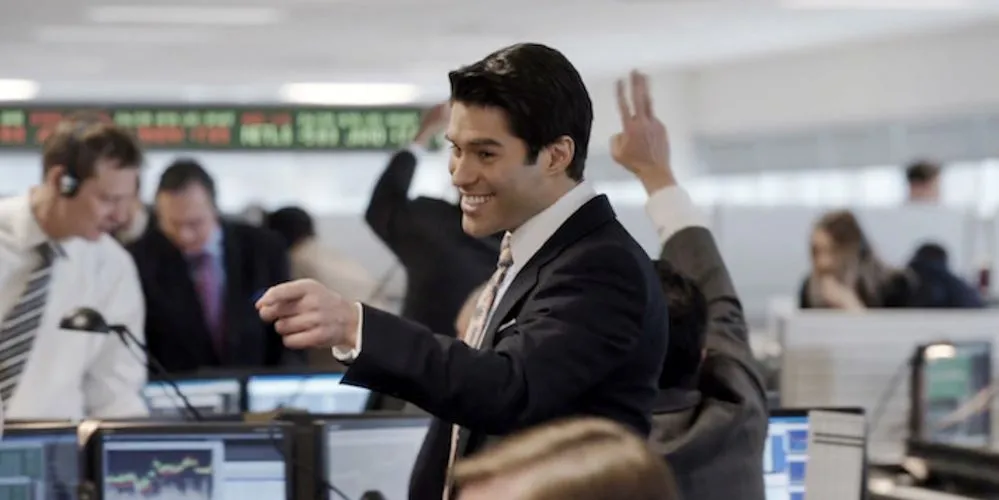 Man in suit smiling and pointing