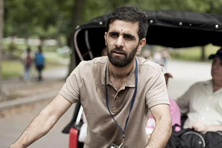 A young man rides a trike in a park.