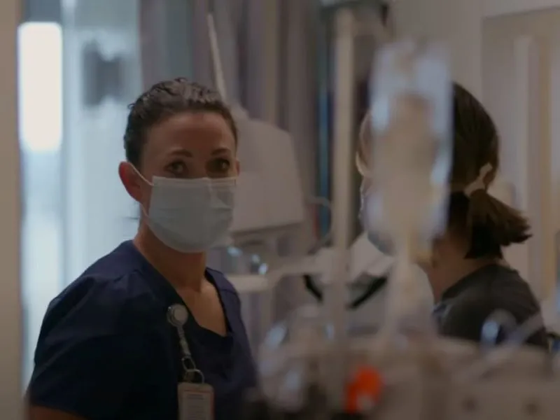 Person wearing surgical mask and medical scrubs