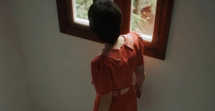 Still of a woman looking out a window from 'Forastera'