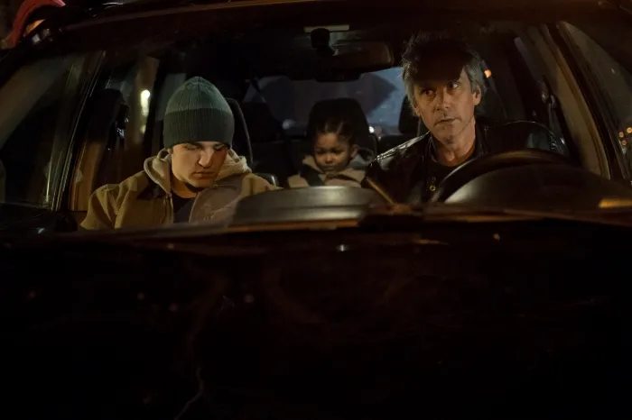 Two man and a kid in a car.