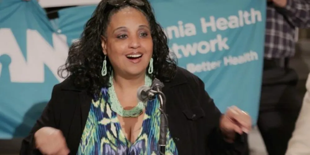 woman seated at desk with microphone
