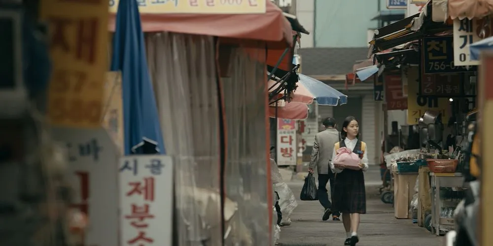 A little kid walks through a street market.