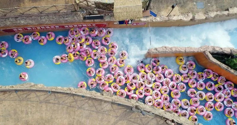 many people in pink innertubes in forked waterway 