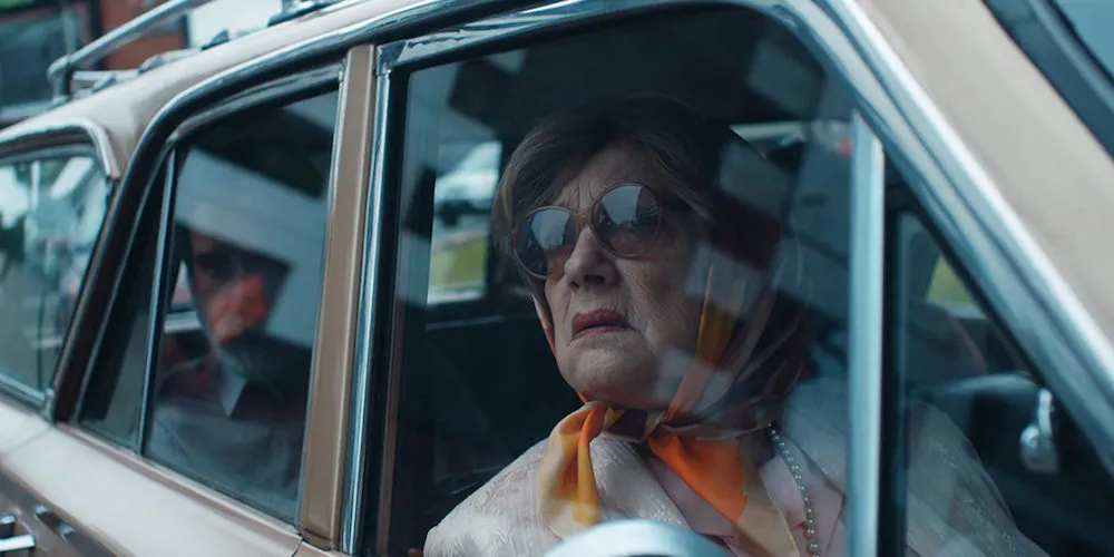Woman in sunglasses looking out of a car window