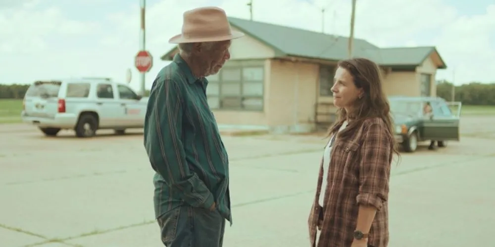man in hat talking to woman at rest stop