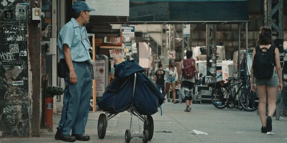Postal worker standing on crowded city sidewalk