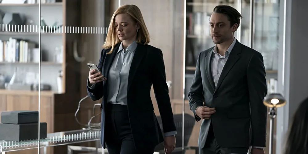 two people in business attire walking through an office