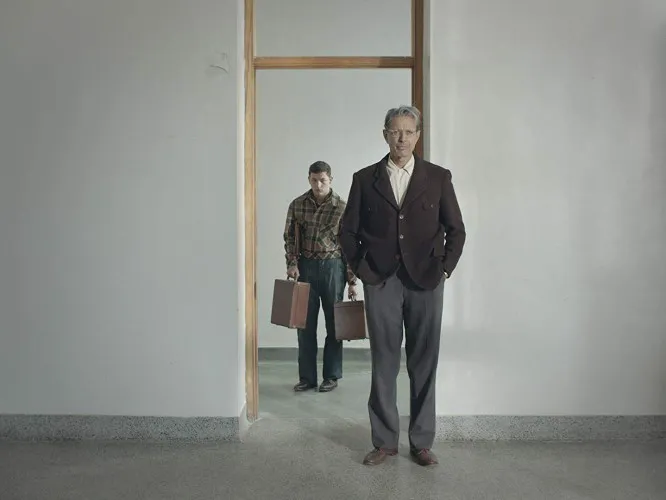 Two man stand by a door frame.
