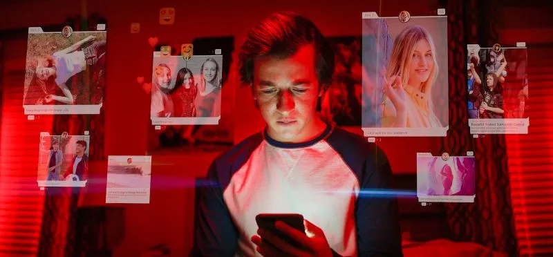 man in red lit room surrounded by semi-translucent photographs