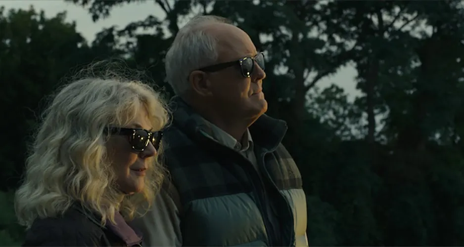 A man and a woman look into the distance.