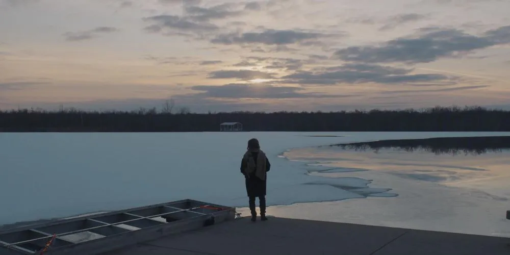 Figure staring over body of water