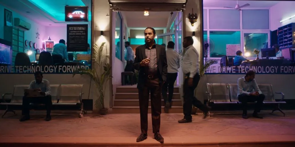 Man standing outside neon-lit store front
