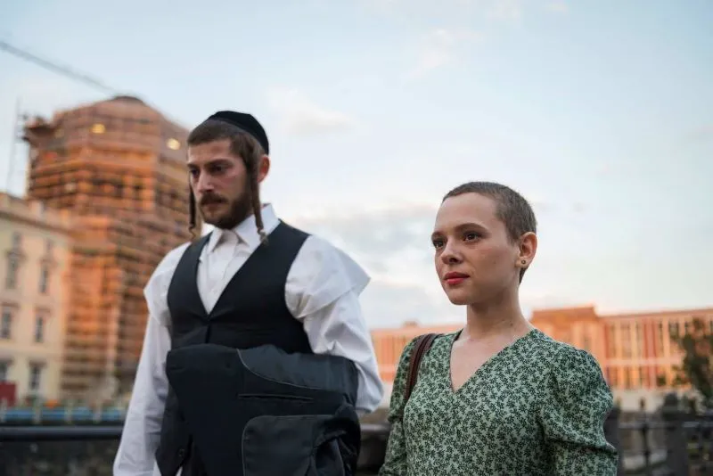 Two people walking through a city street