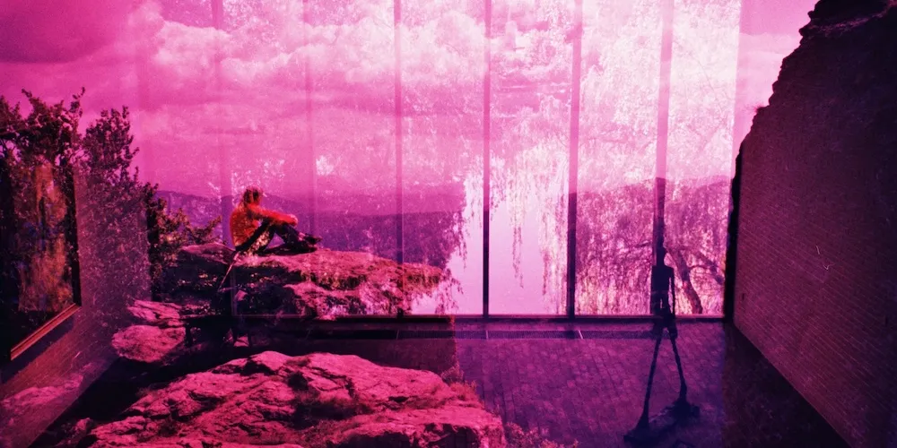 pink-pigmented print of a person outside in the wilderness